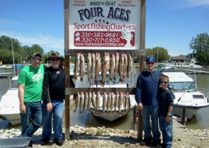 Three men and a kid showing the fish they caught