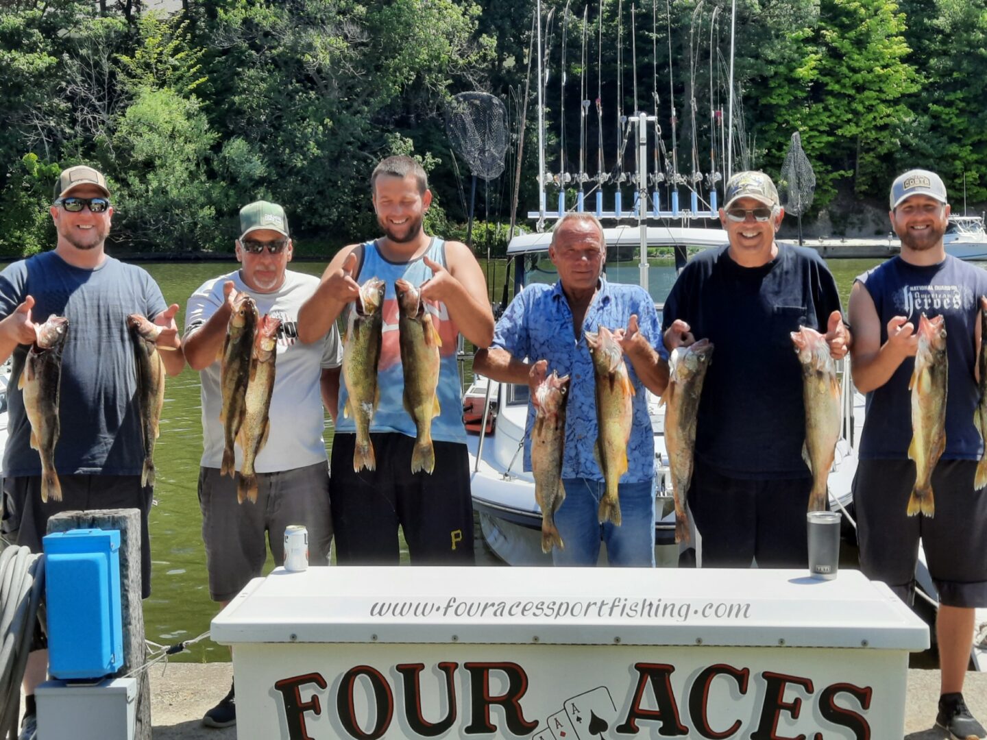 Six men showing the fish that they caught